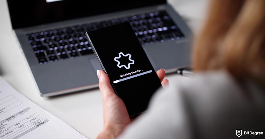 Hardware crypto wallet: a woman installing updates into a device.